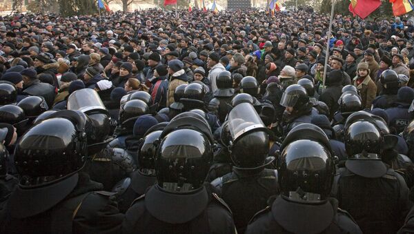 Riot police officers stand in line in front of protesters, some wanting closer links to Russia, others demanding a crackdown on corruption, outside the parliament in Chisinau, Moldova, Thursday, Jan. 21, 2016 - Sputnik International