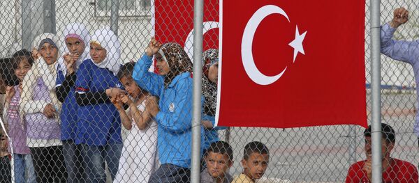 Migrants stand behind a fence at the Nizip refugee camp in Gaziantep province, southeastern Turkey, Saturday, April 23, 2016 - Sputnik International