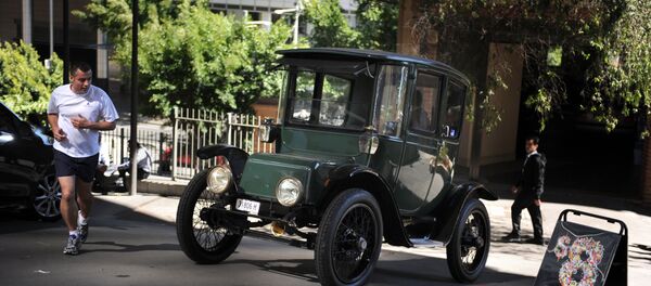 In this photograph taken on September 5, 2012, Bill Lloyd, 61, (obscured) a retired Australian mechanical engineer, patent attorney and vintage car collector sits in his 1915 Detroit electric car out of the garage in Sydney - Sputnik International