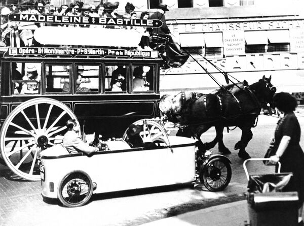 The old and the new meet on a Boulevard of the former French capital. The little electric car passes an old-time horse-drawn car in Paris on Nov. 1, 1941, which has been put back into service as a result of the gasoline shortage - Sputnik International