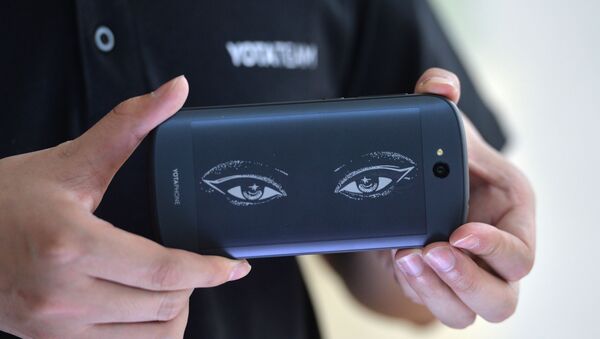 This picture taken on May 20, 2015 shows a staff showcasing the always-on screen of YotaPhone 2 during a press conference in Beijing - Sputnik International
