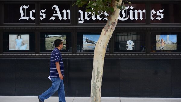 A pedestrian walks past a display of photographs at the Los Angeles Times Building in downtown Los Angeles, California on July 10, 2013 - Sputnik International