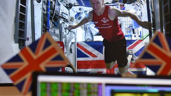 British astronaut Tim Peake is seen on a video screen transmitted from the International Space Station (ISS) at the astronaut centre of the European Space Agency ESA in Cologne, Germany, Sunday, April 24, 2016. Peake ran a 42 kilometre marathon on a tread mill in space onboard the (ISS). - Sputnik International