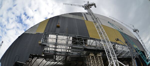 Workers walk man machinery in front of the shelter and containment area built over the destroyed fourth block of the Chernobyl nuclear power plant as they work on the construction of the New Safe Confinement structure (NSC) near Pripyat on April 16, 2016 Workers walk man machinery in front of the shelter and containment area built over the destroyed fourth block of the Chernobyl nuclear power plant as they work on the construction of the New Safe Confinement structure (NSC) near Pripyat on April 16, 2016 - Sputnik International