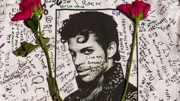 Flowers lay on a T-shirt signed by fans of singer Prince at a makeshift memorial place created outside Apollo Theater in New York. - Sputnik International