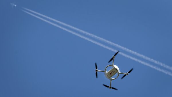 A drone carrying a mail box of Swiss Post flies past on July 7, 2015 above the airport of Bellechasse, western Switzerland - Sputnik International