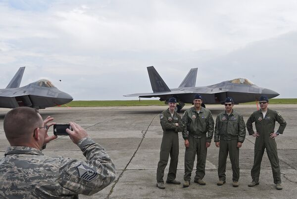US pilots pose for a photograph in front of US F-22 Raptor fighters parked on the runway at Mihail Kogalniceanu air base in Romania April 25, 2016. US pilots pose for a photograph in front of US F-22 Raptor fighters parked on the runway at Mihail Kogalniceanu air base in Romania April 25, 2016. - Sputnik International