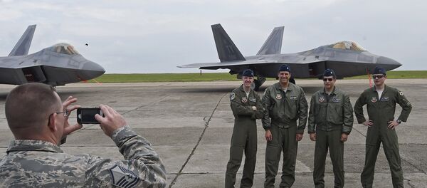 US pilots pose for a photograph in front of US F-22 Raptor fighters parked on the runway at Mihail Kogalniceanu air base in Romania April 25, 2016. US pilots pose for a photograph in front of US F-22 Raptor fighters parked on the runway at Mihail Kogalniceanu air base in Romania April 25, 2016. - Sputnik International