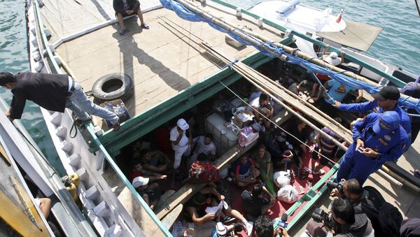 In this May 12, 2013 file photo, Iranian asylum seekers who were caught in Indonesian waters while sailing to Australia sit on a boat at Benoa port in Bali, Indonesia. Papua New Guinea's Supreme Court on Tuesday, April 26, 2016 ruled that Australia's detention of asylum seekers at a facility on the country's Manus Island is unconstitutional. - Sputnik International
