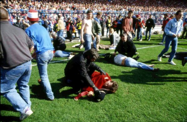 FILE - In this April 15, 1989 file photo police, stewards and supporters tend and care for wounded supporters on the field at Hillsborough Stadium, in Sheffield, England. FILE - In this April 15, 1989 file photo police, stewards and supporters tend and care for wounded supporters on the field at Hillsborough Stadium, in Sheffield, England. - Sputnik International