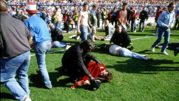 FILE - In this April 15, 1989 file photo police, stewards and supporters tend and care for wounded supporters on the field at Hillsborough Stadium, in Sheffield, England. - Sputnik International