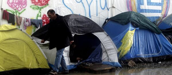 A refugee walks next to tents following heavy rainfall at a makeshift camp for migrants and refugees at the Greek-Macedonian border near the village of Idomeni, Greece, April 24, 2016. - Sputnik International