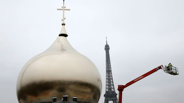 A crane transports a cross to be placed on one of the domes of the future Russian orthodox cathedral Sainte-Trinite at the Quai Branly, near the Eiffel Tower, central Paris, on March 19, 2016. - Sputnik International