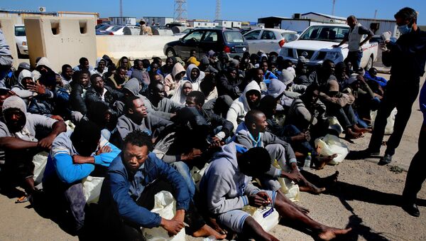 African illegal migrants wait to receive medial assistance after being rescued by coastal guards on a port in Tripoli, Libya. - Sputnik International
