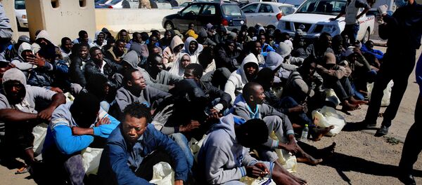 African illegal migrants wait to receive medial assistance after being rescued by coastal guards on a port in Tripoli, Libya. African illegal migrants wait to receive medial assistance after being rescued by coastal guards on a port in Tripoli, Libya. - Sputnik International