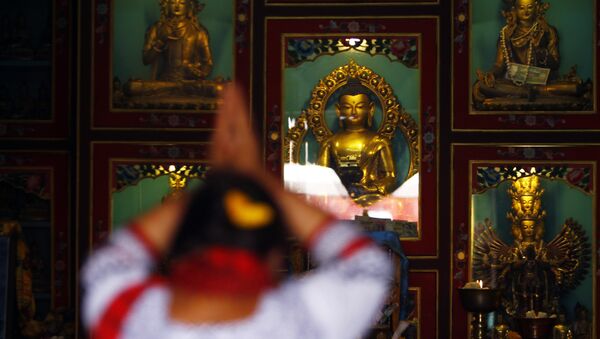 A Buddhist woman offers prayers at a monastery - Sputnik International