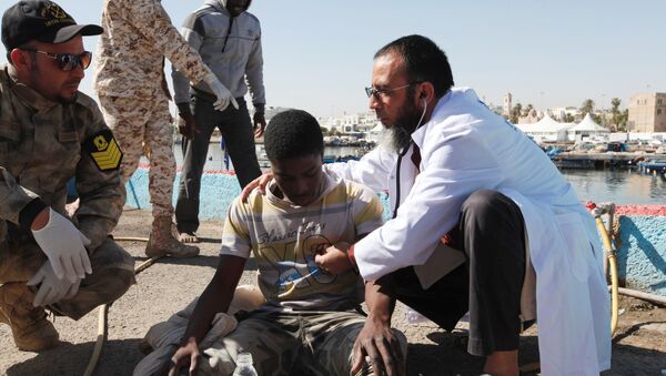 Migrants receive medical treatment in a port, after being rescued at sea by Libyan coast guard, in Tripoli, Libya April 11, 2016 - Sputnik International