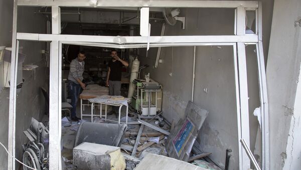 A picture taken on April 28, 2016 shows Syrian men inspecting the damage at the Al-Quds hospital building following reported airstrikes on the rebel-held neighbourhood of Sukkari in the northern city of Aleppo. - Sputnik International