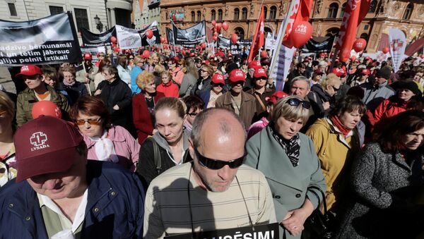 People attend a Free Trade Union Confederation of Latvia rally calling for respectable jobs and respectable remuneration for healthy and educated people in Riga, Latvia, May 1, 2016. Sign in front reads 'We will not be silent!' - Sputnik International