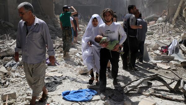 A Syrian family walks amid the rubble of destroyed buildings following a reported airstrike on April 28, 2016 in the Bustan al-Qasr rebel-held district of the northern Syrian city of Aleppo - Sputnik International