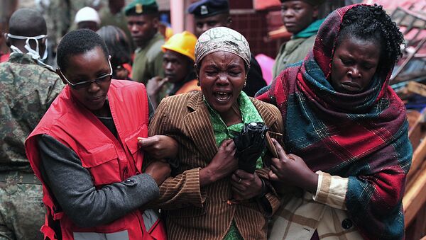 A Kenyan woman (C) mourns the loss of a relative at the site of a building collapse in Nairobi on April 30, 2016. Rescuers in the Kenyan capital made desperate efforts to free survivors including a woman and child trapped in a building that collapsed in storms that have left a total of 17 people dead. - Sputnik International