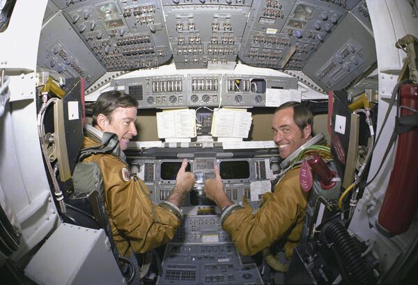 Prime crew astronauts for the first space shuttle mission, Commander John Young and Pilot Robert Crippen, take a break from their intensive training schedule to pose for pictures in the flight deck of the orbiter Columbia. The first Columbia orbiter launched on 12 April 1981 and returned on 14 April, 54.5 hours later, having orbited the Earth 37 times - Sputnik International