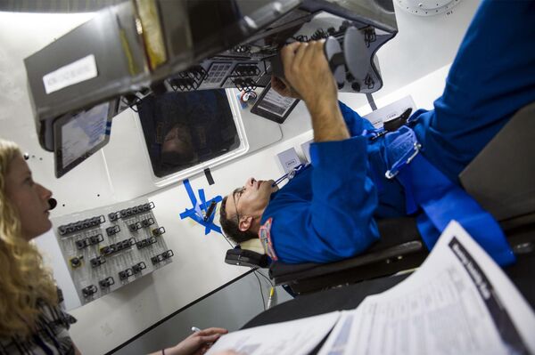 NASA Astronaut Lee Archambault performs an evaluation of reach and visibility of controls and displays during an end-of-year interior layout evaluation of The Boeing Company's CST-100 spacecraft. The spacecraft is expected to fly to the International Space Station with an astronaut aboard by December 2017 - Sputnik International