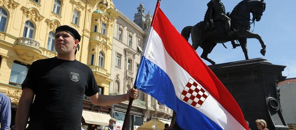 A man holds the Croatian flag as he takes part to a march in support of the Homeland War veterans' rights in Zagreb on April 14, 2015. Croatian leaders April 22, 2016, honoured the victims of the Balkan country's most notorious World War II death camp, in an event boycotted by critics who accuse rulers of tolerating a revival of pro-Nazi ideology A man holds the Croatian flag as he takes part to a march in support of the Homeland War veterans' rights in Zagreb on April 14, 2015. Croatian leaders April 22, 2016, honoured the victims of the Balkan country's most notorious World War II death camp, in an event boycotted by critics who accuse rulers of tolerating a revival of pro-Nazi ideology - Sputnik International