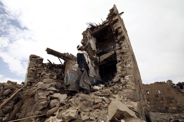 A man points up at a house that was damaged during an airstrike carried out by the Saudi-led coalition in Faj Attan village, Sanaa, Yemen May 7, 2015.  - Sputnik International