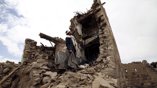 A man points up at a house that was damaged during an airstrike carried out by the Saudi-led coalition in Faj Attan village, Sanaa, Yemen May 7, 2015. - Sputnik International