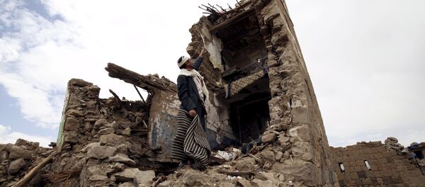 A man points up at a house that was damaged during an airstrike carried out by the Saudi-led coalition in Faj Attan village, Sanaa, Yemen May 7, 2015. - Sputnik International