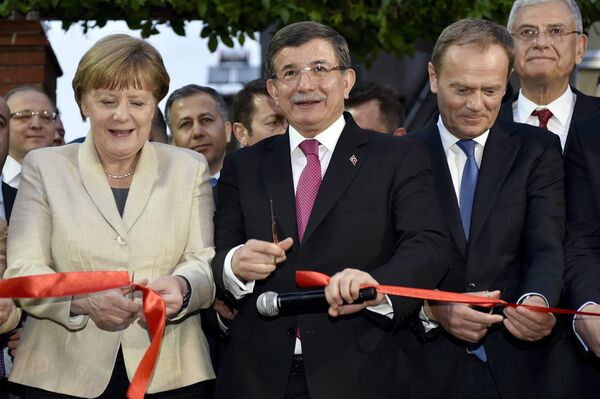 German Chancellor Angela Merkel, Turkish Prime Minister Ahmet Davutoglu and EU Council President Donald Tusk cut a ribbon during a ceremony unveiling a child services center in Nizip refugee camp near Gaziantep, Turkey, April 23, 2016. - Sputnik International