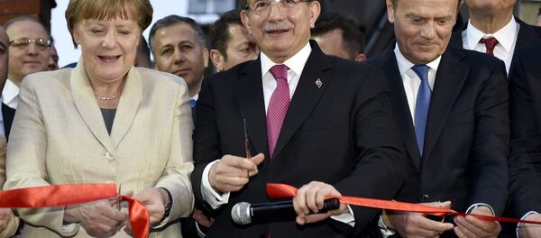 German Chancellor Angela Merkel, Turkish Prime Minister Ahmet Davutoglu and EU Council President Donald Tusk cut a ribbon during a ceremony unveiling a child services center in Nizip refugee camp near Gaziantep, Turkey, April 23, 2016. - Sputnik International