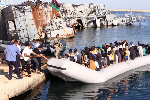 The Libyan coastguard pull a boat carrying illegal African migrants, rescued as they were trying to reach Europe, at a naval base near the capital Tripoli on September 29, 2015. The Libyan coastguard pull a boat carrying illegal African migrants, rescued as they were trying to reach Europe, at a naval base near the capital Tripoli on September 29, 2015. - Sputnik International