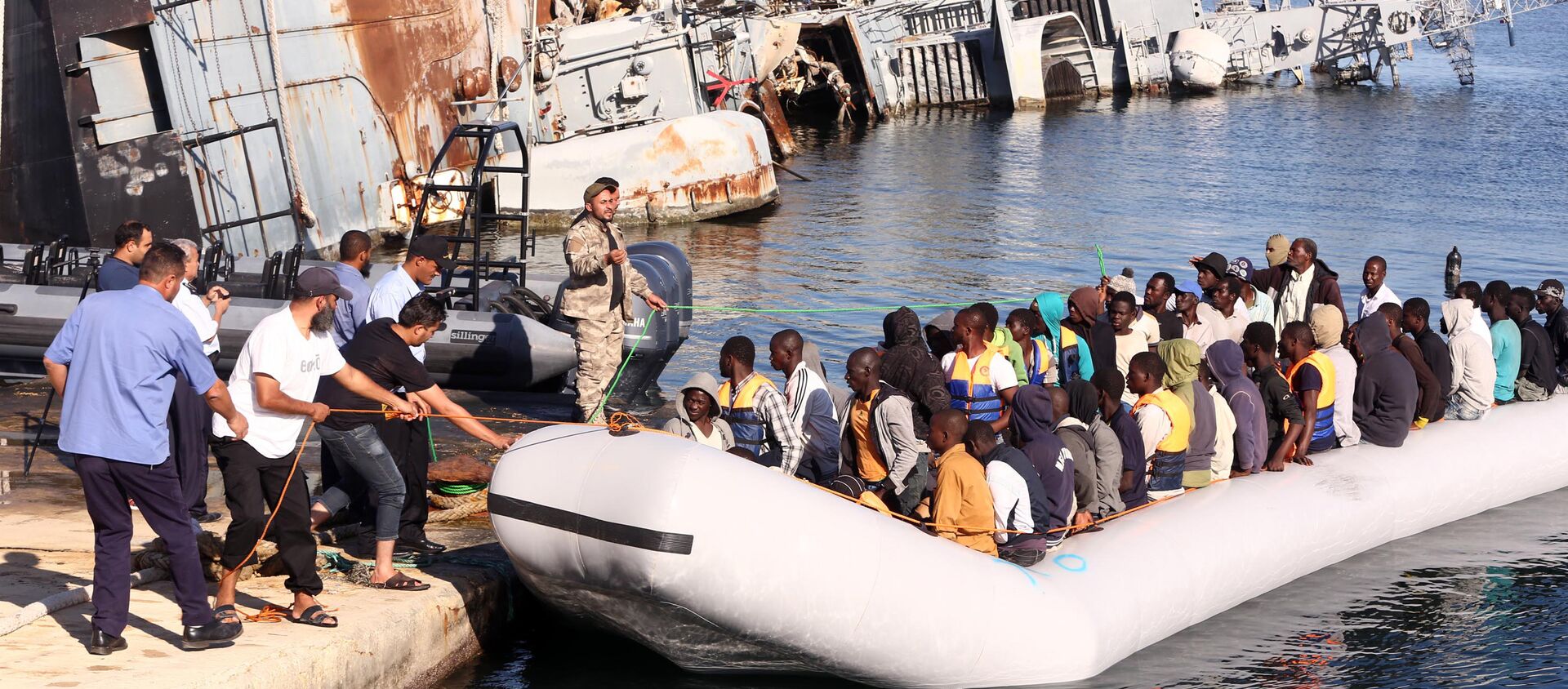 The Libyan coastguard pull a boat carrying illegal African migrants, rescued as they were trying to reach Europe, at a naval base near the capital Tripoli on September 29, 2015.  - Sputnik International, 1920, 24.03.2021