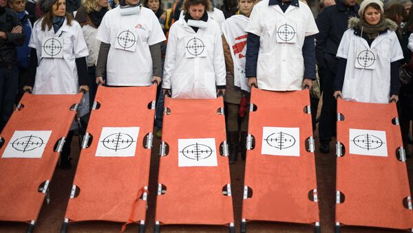 Staffs of Doctors Without Borders, also known by its French name Medecins Sans Frontieres (MSF), hold stretchers with a target on it during a demonstration on November 3, 2015 in Geneva. - Sputnik International