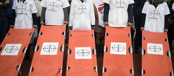 Staffs of Doctors Without Borders, also known by its French name Medecins Sans Frontieres (MSF), hold stretchers with a target on it during a demonstration on November 3, 2015 in Geneva. Staffs of Doctors Without Borders, also known by its French name Medecins Sans Frontieres (MSF), hold stretchers with a target on it during a demonstration on November 3, 2015 in Geneva. - Sputnik International