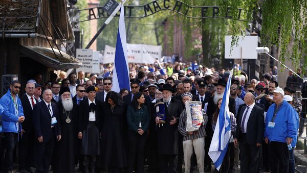 People walk in front of a gate with the words Arbeit macht frei (Work sets you free), in the former Nazi death camp of Auschwitz as thousands of people, mostly youth from all over the world gathered for the annual March of the Living to commemorate the Holocaust in Oswiecim, Poland May 5, 2016. - Sputnik International