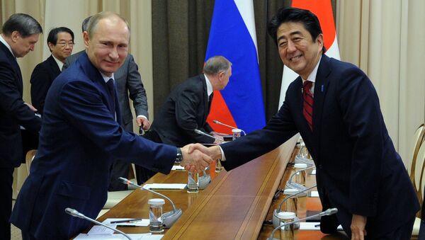 Russian President Vladimir Putin and Japanese Prime Minister Shinzo Abe shake hands at their meeting in the Bocharov Ruchei residence in Sochi, Russia, Saturday, Feb. 8, 2014. - Sputnik International