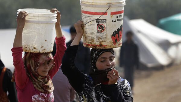Syrian refugee girls carry over their heads buckets of water as they walk at Atmeh refugee camp, in the northern Syrian province of Idlib, Syria - Sputnik International