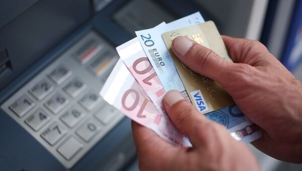 A man takes out Euro banknotes from an automated teller machine (ATM) - Sputnik International