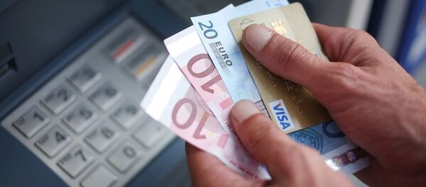 A man takes out Euro banknotes from an automated teller machine (ATM) - Sputnik International