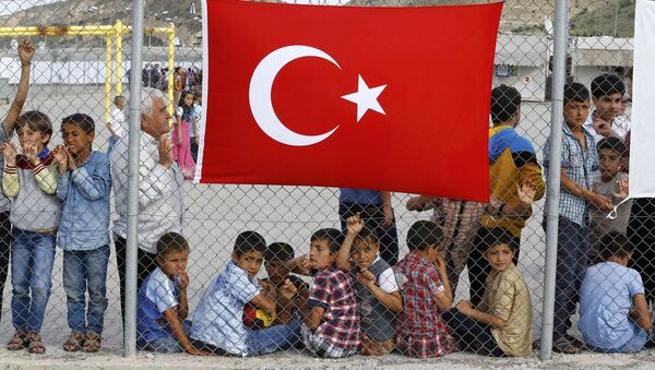 An elderly refugee man stands with children as they wait for the arrival of German Chancellor Angela Merkel, Turkish Prime Minister Ahmet Davutoglu, EU Council President Donald Tusk and European Commission Vice-President Frans Timmermans (all not pictured) at Nizip refugee camp near Gaziantep, Turkey, April 23, 2016.s - Sputnik International