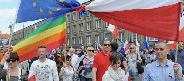 Opponents of Poland's government carry a Polish and EU flags tied together as they march downtown streets to protest the country's direction under a conservative government that is accused of eroding the rule of law, in Warsaw, Poland, Saturday, May 7, 2016. - Sputnik International