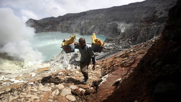 In this April 16, 2016 photo, Marzuki, a sulfur miner, carries baskets of sulfur as he climbs up from the crater of Mount Ijen in Banyuwangi, East Java, Indonesia - Sputnik International