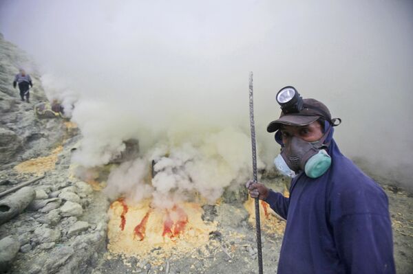 In this April 16, 2016 photo, a sulfur miner pauses as he works at the crater of Mount Ijen in Banyuwangi, East Java, Indonesia In this April 16, 2016 photo, a sulfur miner pauses as he works at the crater of Mount Ijen in Banyuwangi, East Java, Indonesia - Sputnik International