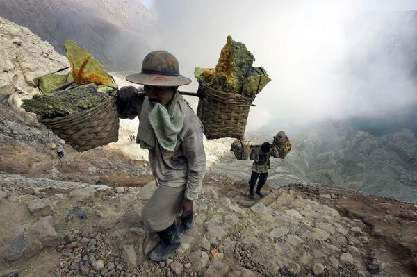 In this Thursday, Aug. 6, 2009 photo, miners carry buckets of sulphur at the crater of Ijen volcano in Bayuwangi, East Java, Indonesia In this Thursday, Aug. 6, 2009 photo, miners carry buckets of sulphur at the crater of Ijen volcano in Bayuwangi, East Java, Indonesia - Sputnik International