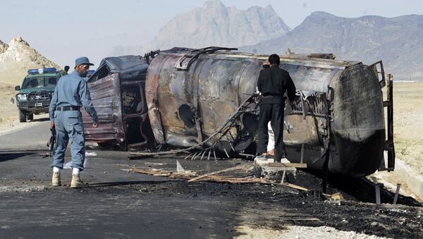 Afghan policemen stand near a burnt out fuel tanker (File) - Sputnik International