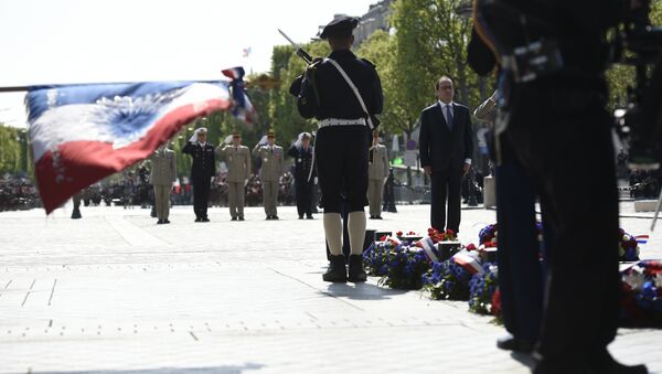 French President Francois Hollande (R) pays his respect at the Tomb of the Unknown Soldier at the base of the Arc de Triomphe during a ceremony marking the 71st anniversary of the victory over Nazi Germany during World War II on May 8, 2016 in Paris - Sputnik International