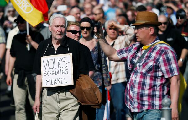 Right-wing protestors demonstrate against refugees, Islam and German Chancellor Angela Merkel in Berlin, Germany, May 7, 2016. The sign reads: Volksschaedling (Enemy of the People) Right-wing protestors demonstrate against refugees, Islam and German Chancellor Angela Merkel in Berlin, Germany, May 7, 2016. The sign reads: Volksschaedling (Enemy of the People) - Sputnik International